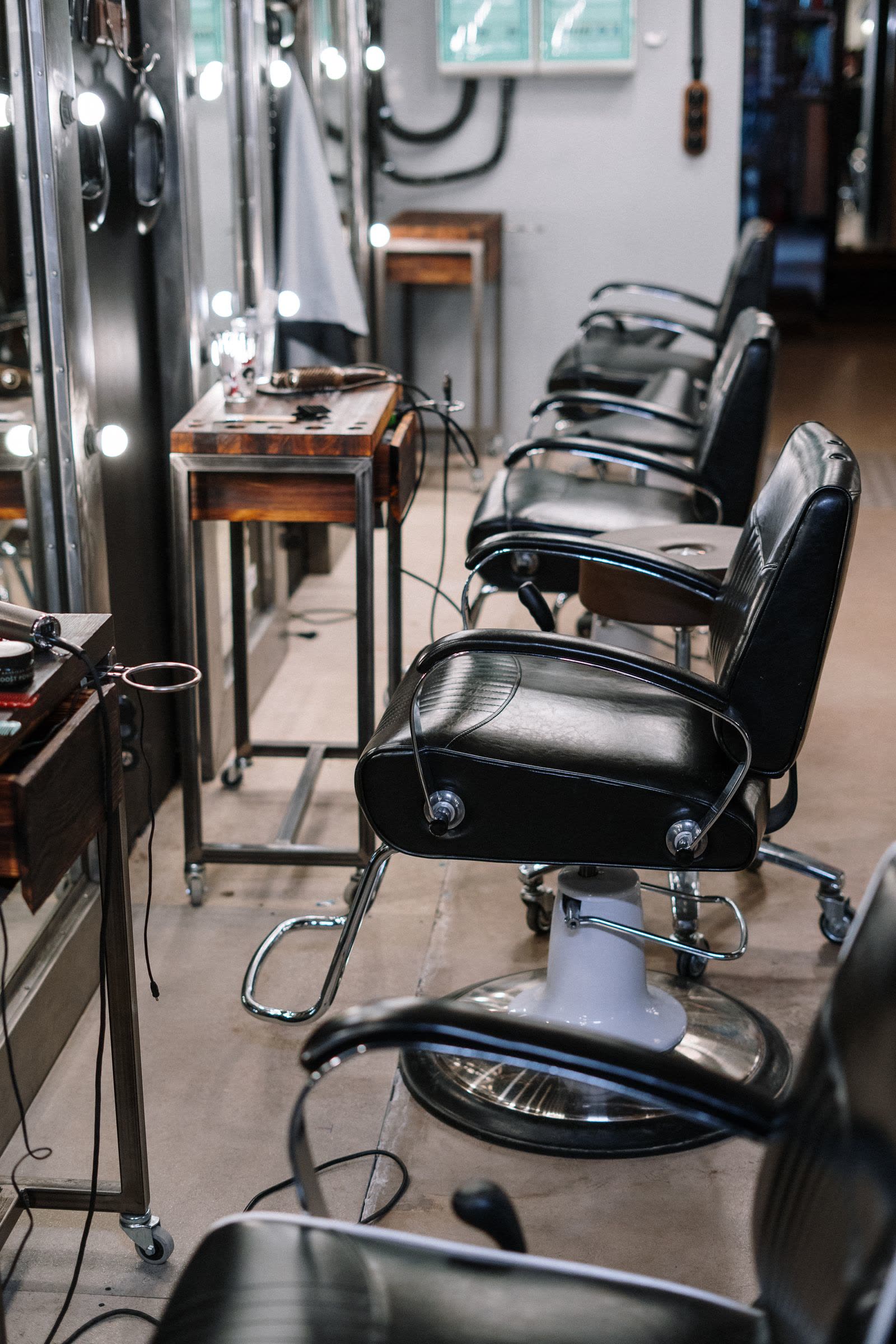 Interior of Vesper Barbers with barber chairs and warm lighting